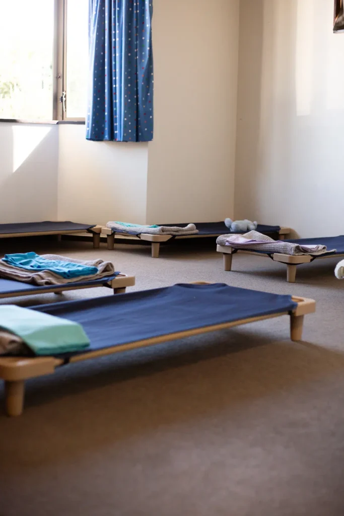 A sleep room at Lilliput Preschool with beds made up ready for moe